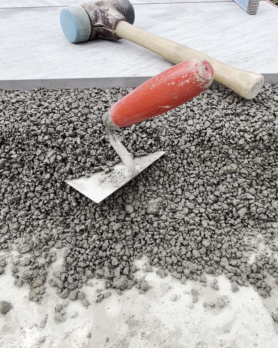 Keramikplatte wird in das frische Drainbeton-Bett gelegt