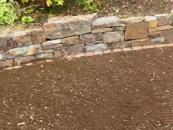 Vorher: planierter Boden vor der Natursteinmauer